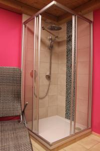 a shower in a bathroom with a chair in a room at Seepension Neubacher KG in Nussdorf am Attersee