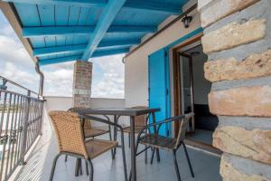 einen Tisch und Stühle auf einem Balkon mit blauer Decke in der Unterkunft Apartman Rocky in Petrovija