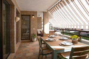 a dining room with a table and chairs on a balcony at MENDILAUTA in Zarautz