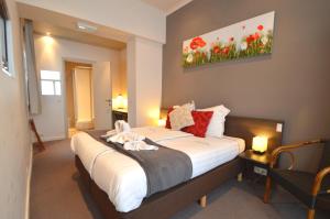 um quarto com uma cama grande num quarto em Hotel Ambrosia em Ypres