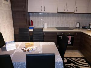 una cucina con tavolo, sedie e bancone di Airport's Close, Cozy Flat for 6 Persons a Markopoulo