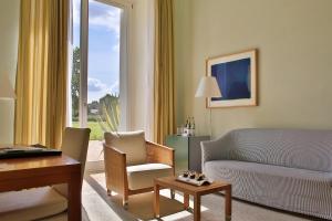 a living room with a couch and a table at Hotel Schloss Neuhardenberg in Neuhardenberg