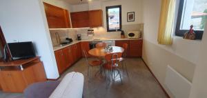 a small kitchen with a table and chairs in it at Bay View Villas Nina 12c in Kosharitsa