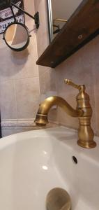 lavabo con grifo de oro y espejo en Bay View Villas Nina 12c, en Kosharitsa