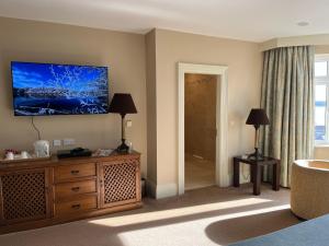 a living room with a television on a wall at St Kyrans Guest House in Virginia