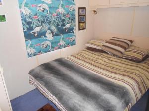 a bedroom with a bed with a painting on the wall at 'The Cabin'. A cosy private & secure holiday home. in Padeswood