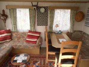 a living room with a couch and a table at 'The Cabin'. A cosy private & secure holiday home. in Padeswood