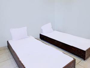 un par de camas en una habitación en SPOT ON 92374 Penginapan Rusunawa, en Malang