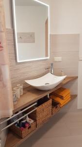 a bathroom with a white sink and a mirror at Ferienwohnung Mittelmühle in Teupitz