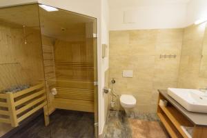 uma casa de banho com um chuveiro, um WC e um lavatório. em Apartment am Sonnenhang Top 6 em Neukirchen am Grossvenediger