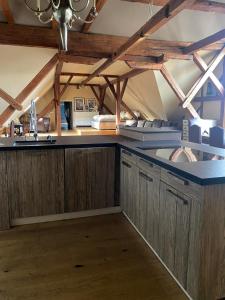 a kitchen with wooden cabinets and a ceiling with beams at Altbauwohnung mit Fachwerk in Anif