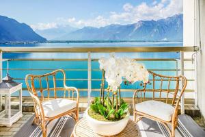 a balcony with two chairs and a table with a plant at Montreux paradise top view in Montreux