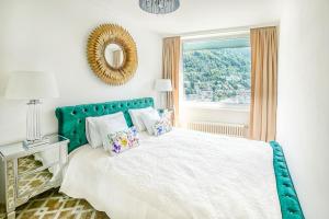 Schlafzimmer mit einem Bett mit einem grünen Kopfteil und einem Fenster in der Unterkunft Montreux paradise top view in Montreux
