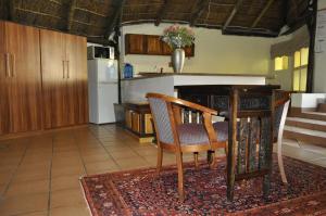 a kitchen with a table and chairs and a refrigerator at Cashan BnB in Rustenburg