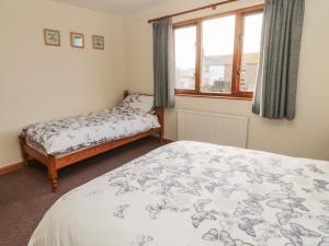 a bedroom with a bed and a window at Causeway Cottage in Berwick-Upon-Tweed