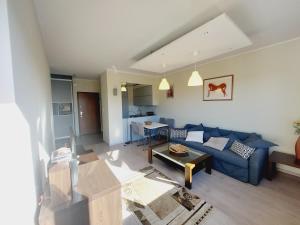 salon z niebieską kanapą i stołem w obiekcie Central Apartments Garnizon 928 & Parking w Gdańsku