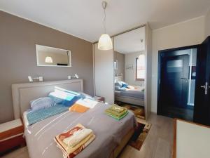 sypialnia z łóżkiem i lustrem w obiekcie Central Apartments Garnizon 928 & Parking w Gdańsku