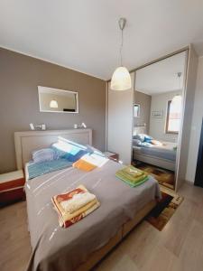 sypialnia z dużym łóżkiem i lustrem w obiekcie Central Apartments Garnizon 928 & Parking w Gdańsku