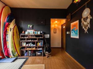 a room with a book shelf with surfboards in it at Panorama in Yomitan