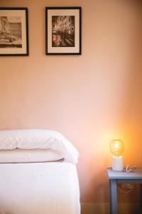 Cute and charming suite في فلورنسا: غرفة نوم بسرير وصورتين على الحائط