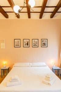 een slaapkamer met een wit bed met drie foto's aan de muur bij Cute and charming suite in Florence