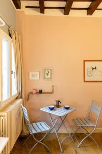 een tafel en stoelen in een kamer met een raam bij Cute and charming suite in Florence