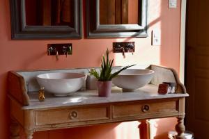 - 2 lavabos sur une table en bois dans la salle de bains dans l'établissement Château Richelieu, à Fronsac