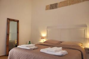 1 dormitorio con 1 cama con toallas en SEA FRONT, Allegria, Santa Maria al Bagno, en Nardò