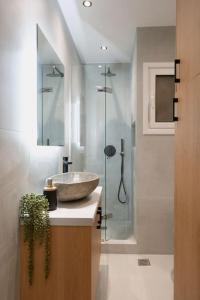 La salle de bains est pourvue d'un lavabo et d'une douche en verre. dans l'établissement The Heart Of Athens, à Athènes