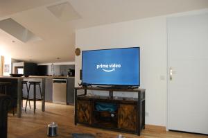 a flat screen tv sitting on a stand in a living room at Le Montferrand - Jules Guesde Appartement rénové lumineux in Clermont-Ferrand