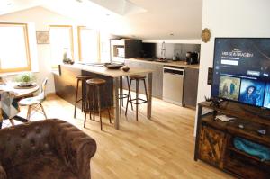 a living room with a kitchen and a table with a tv at Le Montferrand - Jules Guesde Appartement rénové lumineux in Clermont-Ferrand