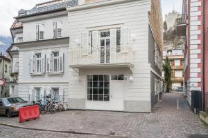 - un bâtiment blanc avec un balcon dans une rue dans l'établissement Villa Steiner 5 - Suzuka, à Merano