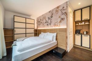 - une chambre avec un grand lit blanc et des placards en bois dans l'établissement Villa Steiner 5 - Suzuka, à Merano