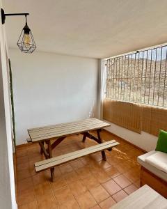 una mesa de picnic en una habitación con ventana en RentitSpain Puerta de la Ragua, en Picena