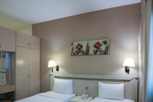um quarto de hotel com duas camas e duas lâmpadas em West Zone Pearl Hotel Apartment no Dubai