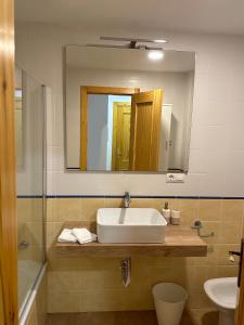 y baño con lavabo y espejo. en RentitSpain Puerta de la Ragua, en Picena