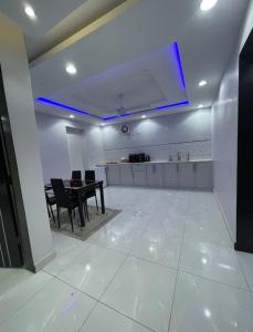 une salle à manger avec une table et une lumière bleue dans l'établissement شاليهات قولدن GOLDEN محايل, à Muhayil