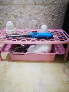 un cajón rosa con un par de tijeras y otros artículos en شاليهات قولدن GOLDEN محايل, en Muhayil