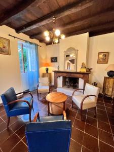 ein Wohnzimmer mit Stühlen, einem Tisch und einem Spiegel in der Unterkunft A Funtanella, maison de caractere situe entre montagne et mer in Tavera