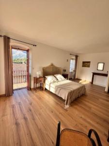 1 dormitorio con 1 cama y suelo de madera en A Funtanella, maison de caractere situe entre montagne et mer, en Tavera