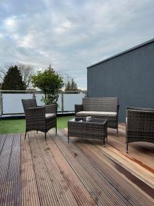 three wicker chairs and a couch on a deck at Villa Hilden in Hilden