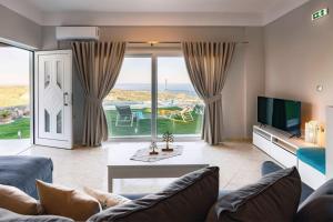 a living room with a couch and a tv at Villa Panthea in Keratokampos
