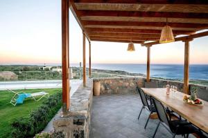a patio with a table and chairs and the ocean at Villa Panthea in Keratokampos