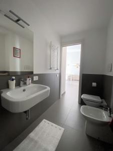 a white bathroom with a sink and a toilet at Casa Balo Pozzuoli in Pozzuoli