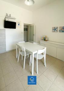 een witte tafel en witte stoelen in een keuken bij The Family Nest - Casa Eva in Manfredonia