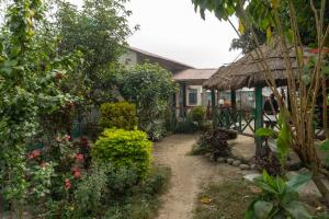 a garden in front of a house with plants at Ayodhyapuri Community Homestay in Chitwan