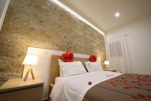 a bedroom with a large bed with red flowers on it at Boscò Suites in Carini