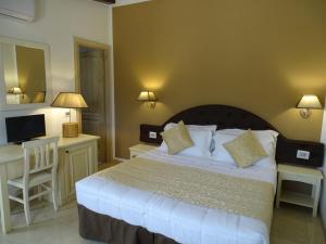 Dormitorio con cama, escritorio y TV en Locanda Domus De Vida Turismo Rurale, en Palau