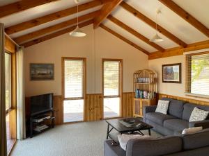 a living room with a couch and a tv at Warby Cottage in Wangaratta