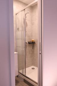 a shower with a glass door in a bathroom at Orléans in Paris